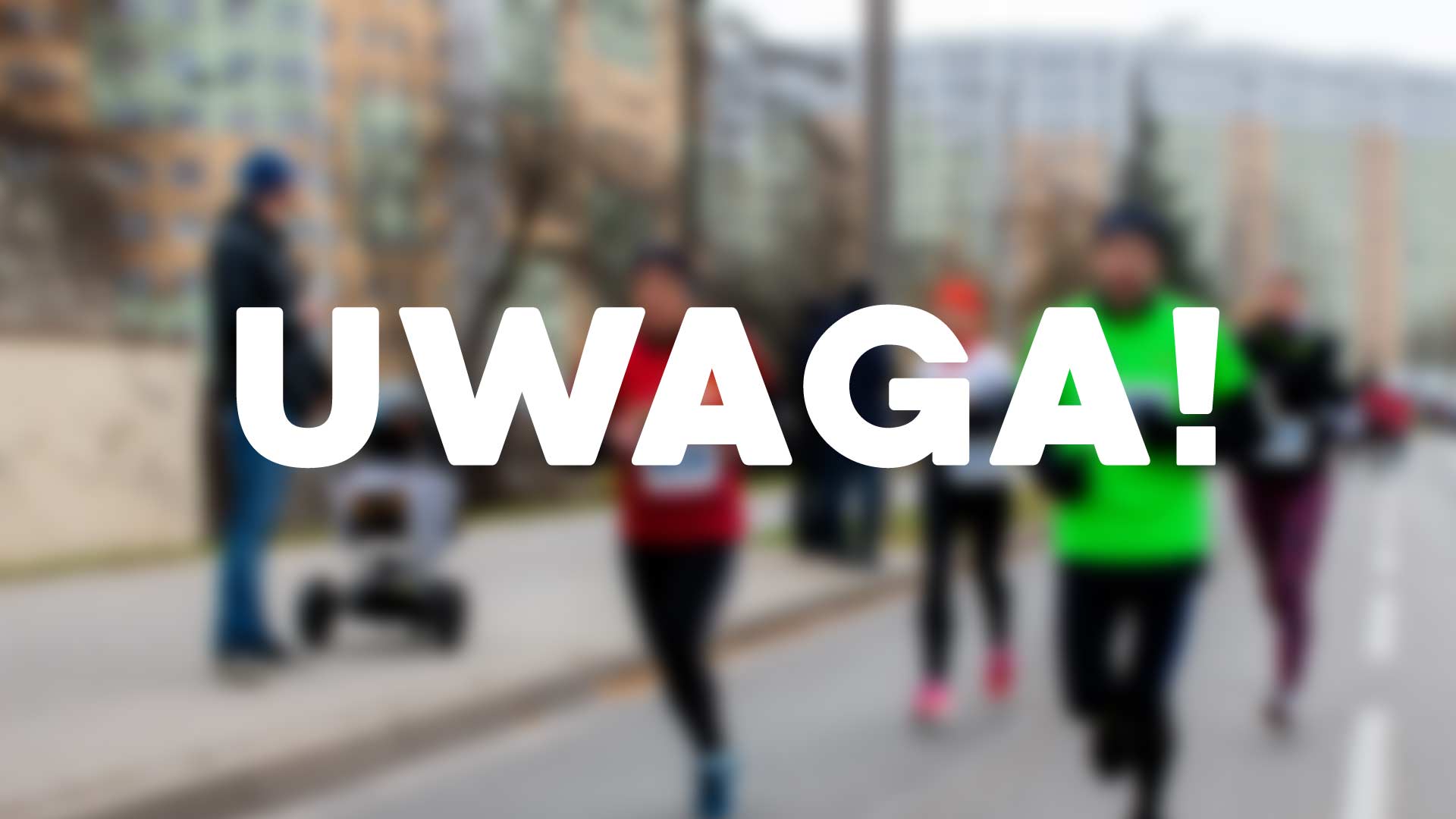 Napis UWAGA na tle biegaczy