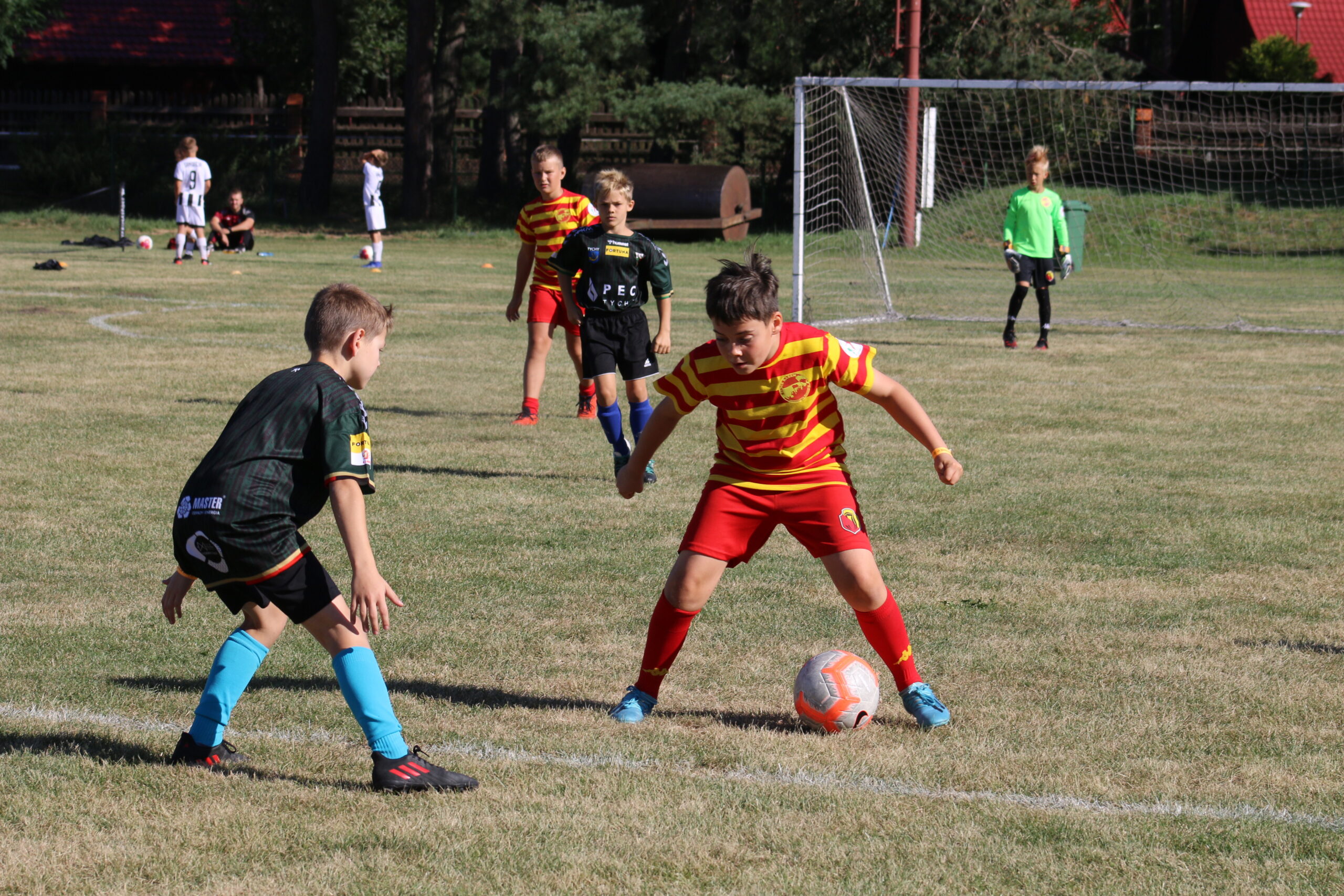 na zdjęciu chłopcy grający w piłkę nożną na boisku piłkarskim