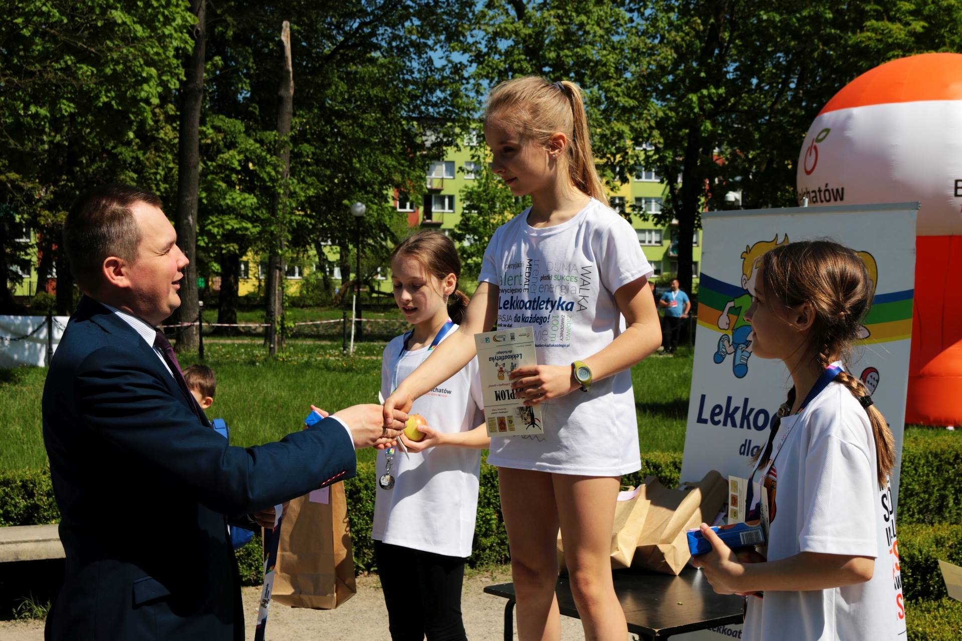 na zdjęciu widoczna uczestniczka Biegu Konstytucji 3 Maja, która odbiera gratulacje z rąk Pana Łukasza Politańskiego - Wiceprezydenta Miasta Bełchatowa