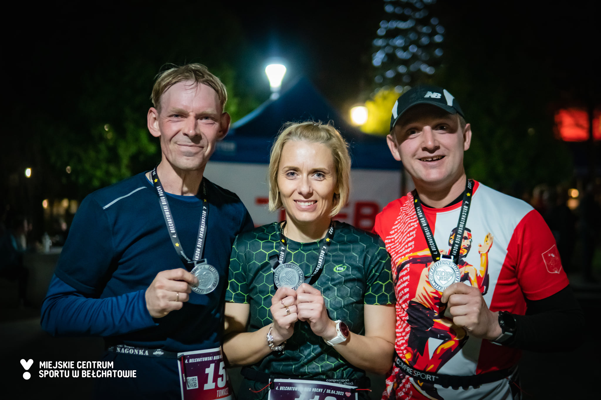 na zdjęciu widoczni uśmiechnięci biegacze po ukończeniu 4. Bełchatowskiego Biegu Nocnego wraz z medalami